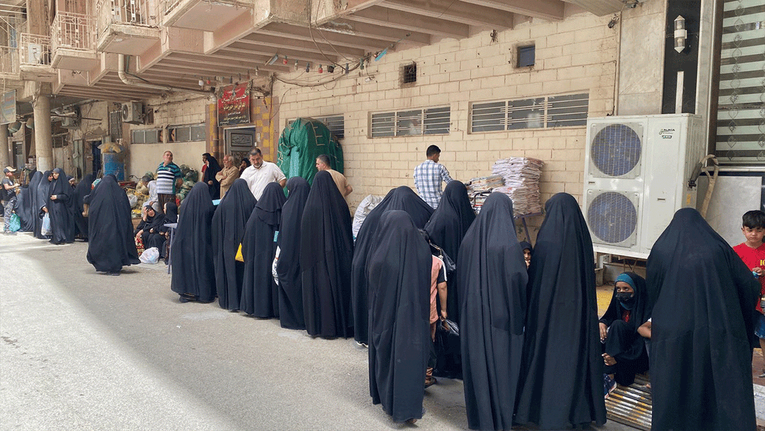 Women standing in line to receive aid parcels