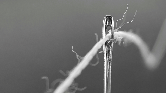 single thread and needle. photo by Vasilica Ciocan on unsplash.com