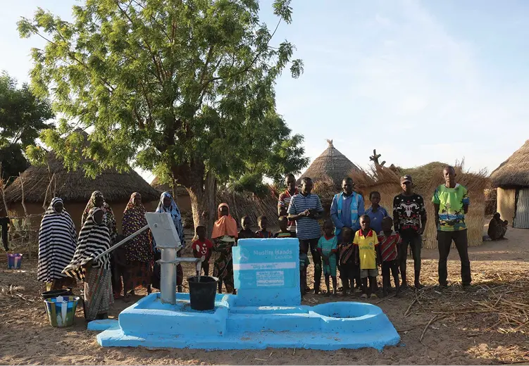 African community gathered around a SABR-funded water well built in partnership with Muslim Hands