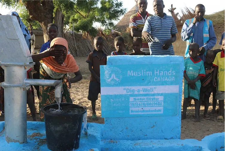 Community members gathered around a SABR-funded Muslim Hands Dig-a-Well water well in Africa